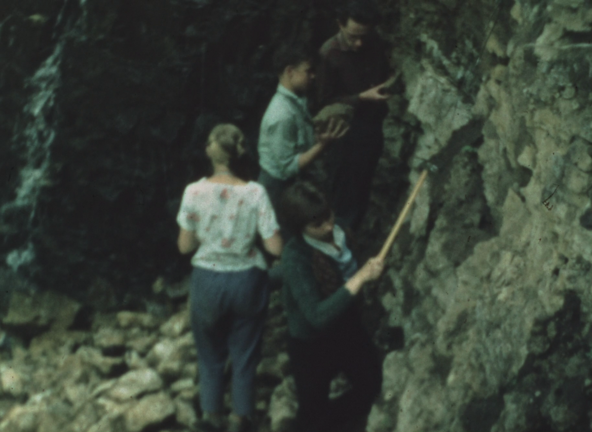 5. attēls. Ievācot iežu paraugus kopā ar Jauno ģeologu pulciņa dalībniekiem ap 1964. gadu. Kadrs no dokumentālās filmas: no Latvijas Valsts kinofotofonodokumentu arhīva 5. attēls. Ievācot iežu paraugus kopā ar Jauno ģeologu pulciņa dalībniekiem ap 1964. gadu. Kadrs no dokumentālās filmas: no Latvijas Valsts kinofotofonodokumentu arhīva